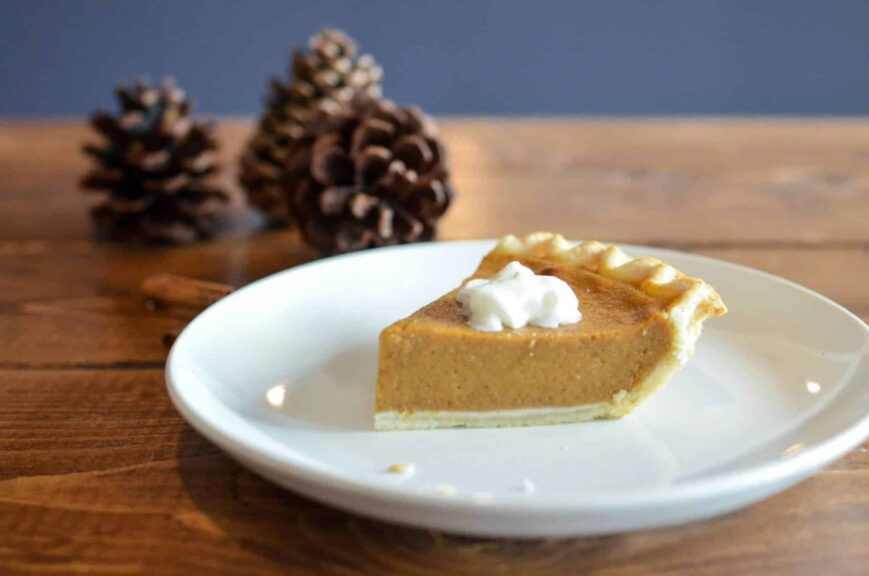 Close-up of a pumpkin pie slice with whipped cream, perfect for fall desserts. Costco
