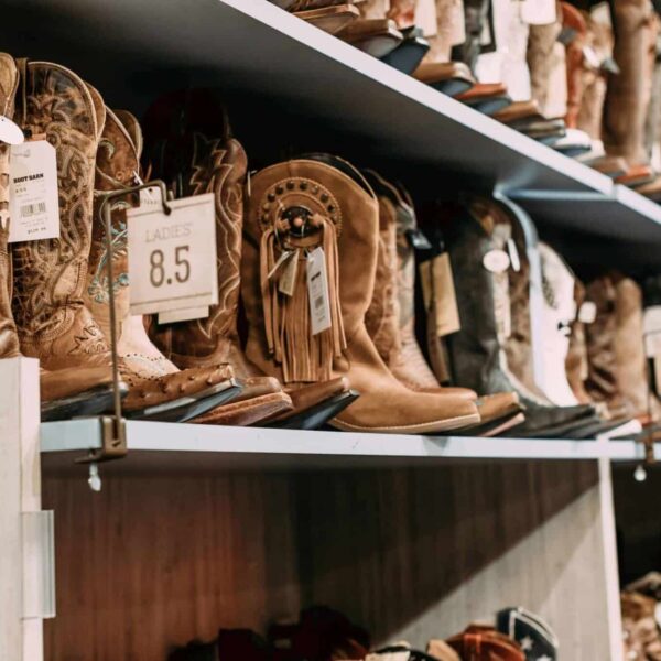 fall boots, Variety of cowboy boots displayed on shelves in a fashionable footwear store.