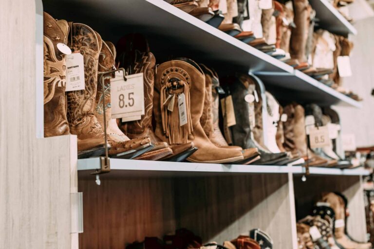 fall boots, Variety of cowboy boots displayed on shelves in a fashionable footwear store.