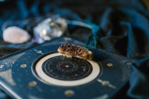 T-Square,Close-up of crystals on an astrology chart atop dark fabric for a mystical vibe.