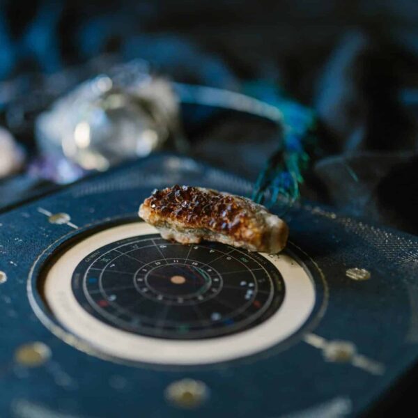T-Square,Close-up of crystals on an astrology chart atop dark fabric for a mystical vibe.