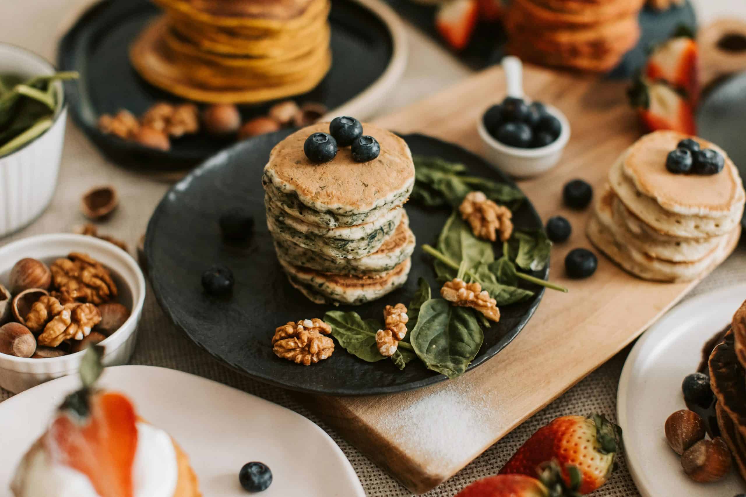 Delectable stack of pancakes topped with blueberries and walnuts, ideal for breakfast or dessert inspiration.
