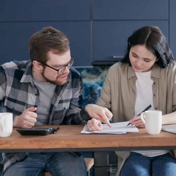 financial intimacy: Interracial couple discussing bills and financial planning in a cozy indoor setting.
