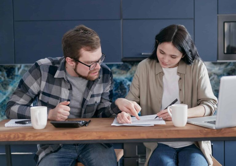 financial intimacy: Interracial couple discussing bills and financial planning in a cozy indoor setting.