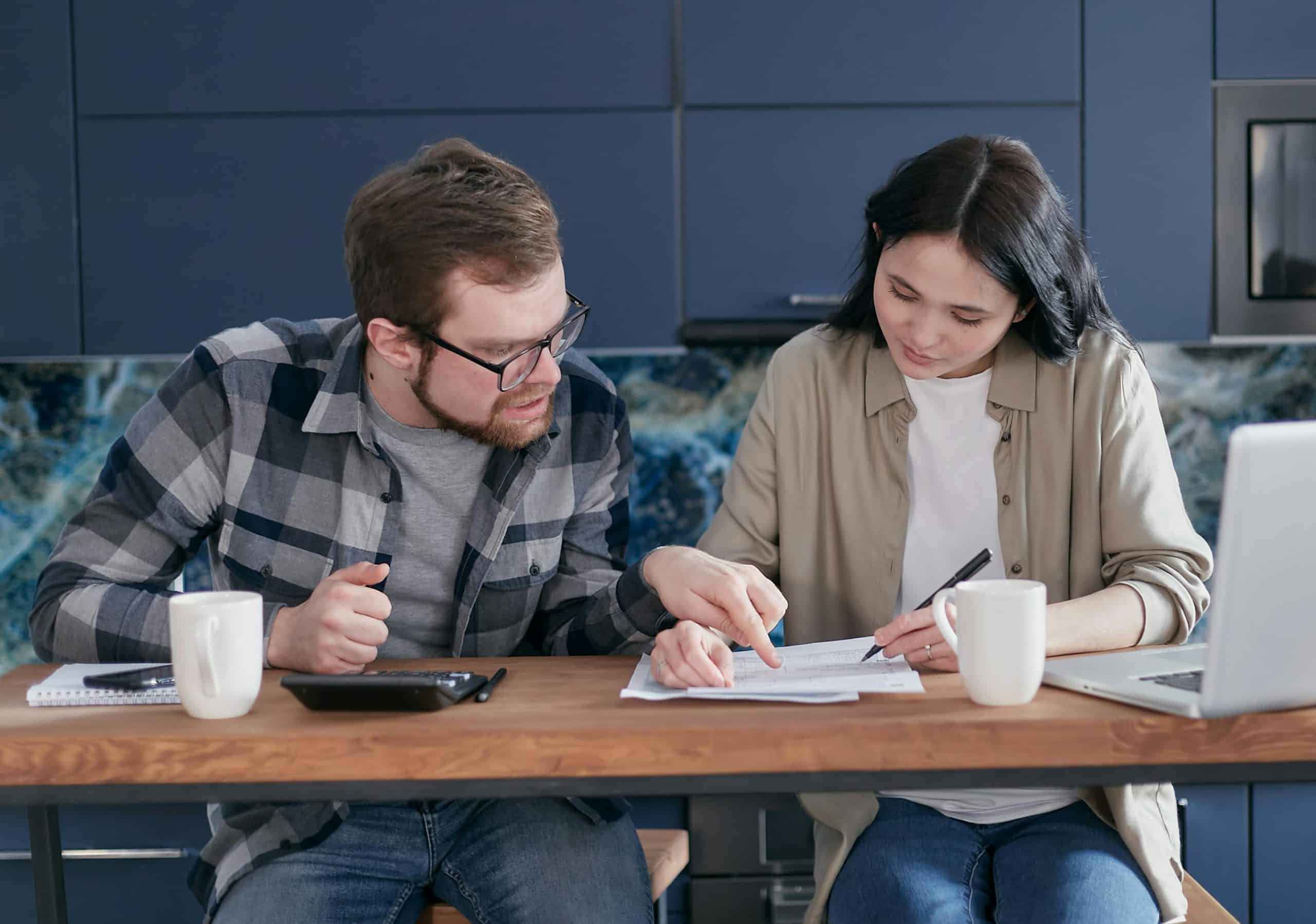financial intimacy: Interracial couple discussing bills and financial planning in a cozy indoor setting.