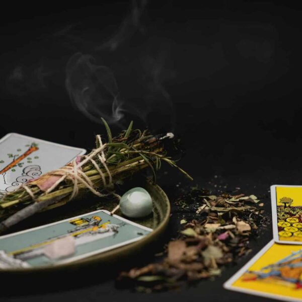 Tarot horoscope A spiritual still life with tarot cards, herbs, and crystals on a dark surface for meditation.
