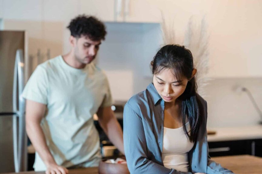 A couple having a serious conversation in a modern kitchen setting. gray rocking