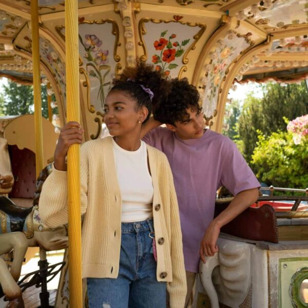 creative, meet your date, Young couple enjoying a carousel ride in a colorful amusement park setting. Perfect for lifestyle themes.