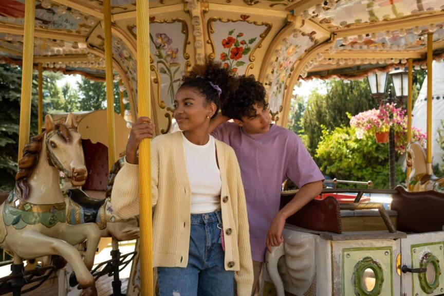 creative, meet your date, Young couple enjoying a carousel ride in a colorful amusement park setting. Perfect for lifestyle themes.