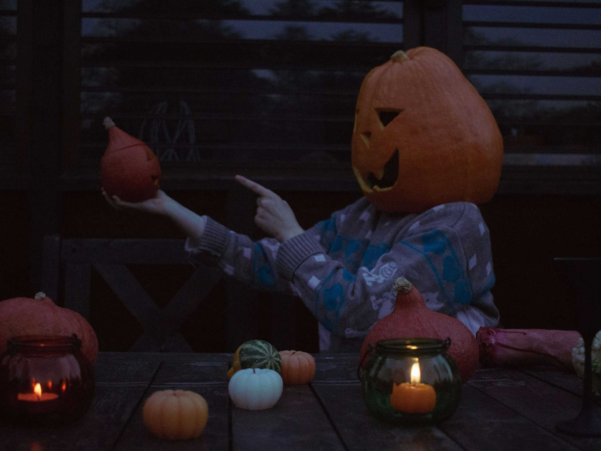 Person wearing a pumpkin head and spooky sweater Photo by Annie Smurova on Unsplash