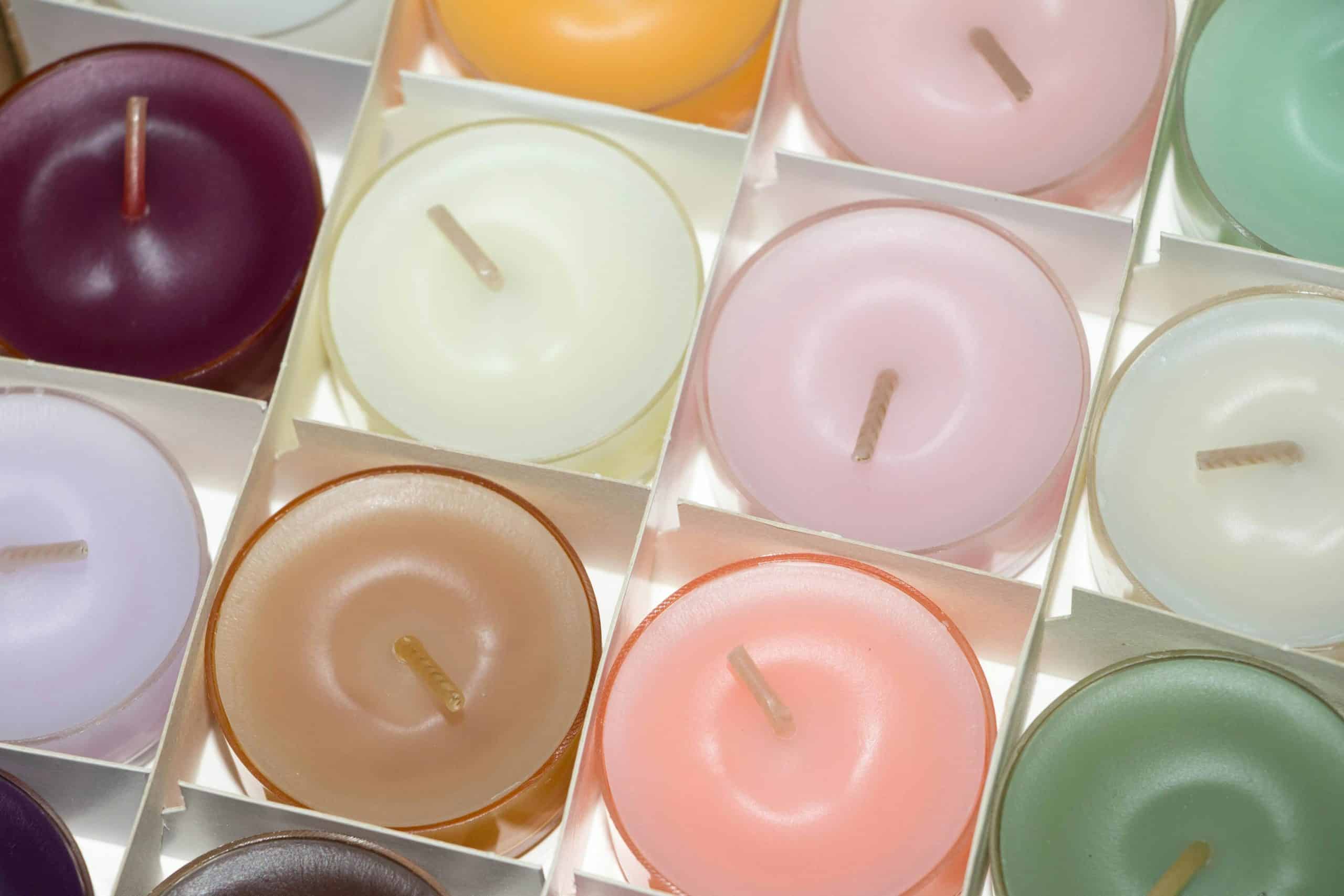 Colorful array of scented tea light candles in a decorative setting.