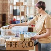 A volunteer organizes free food donations in an indoor community center setting. SNAP benefits leave, food banks step in.