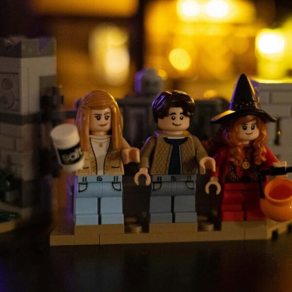 Three lego figures in a castle setting, Allison Watts, Max Dennison and Dani Dennison stand outside the gate in this LEGO set recreation from the 1993 classic "Hocus Pocus."