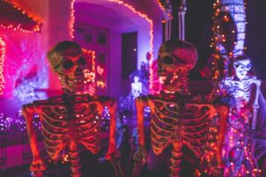 two skeleton near white concrete building with string lights at daytime. Halloween decorations, decor, october prime day, halloween decor deals