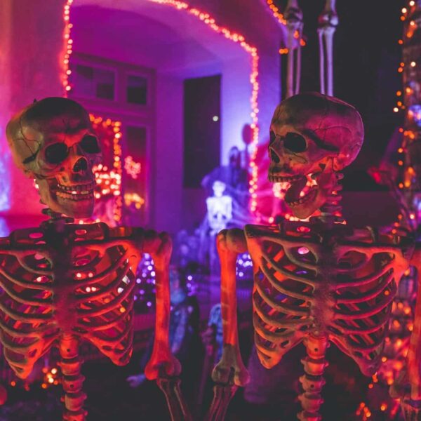 two skeleton near white concrete building with string lights at daytime. Halloween decorations, decor, october prime day, halloween decor deals