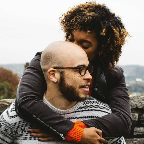 woman kissing man's head