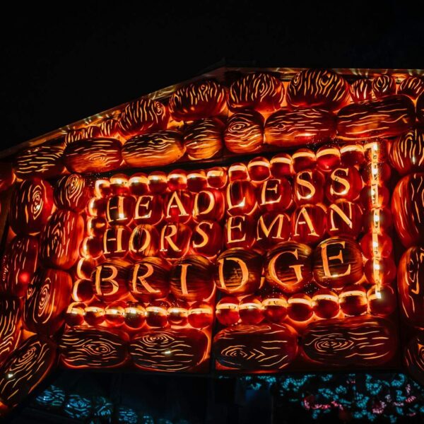 a lit up sign that says, headless horseman bridge Sleepy Hollow New York