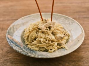Delicious fettuccine alfredo with chicken on a rustic wooden table. pasta recall