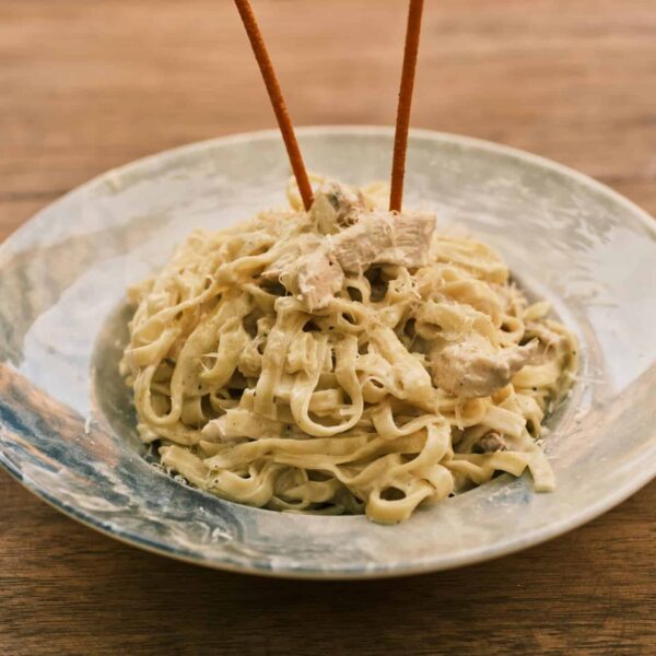 Delicious fettuccine alfredo with chicken on a rustic wooden table. pasta recall