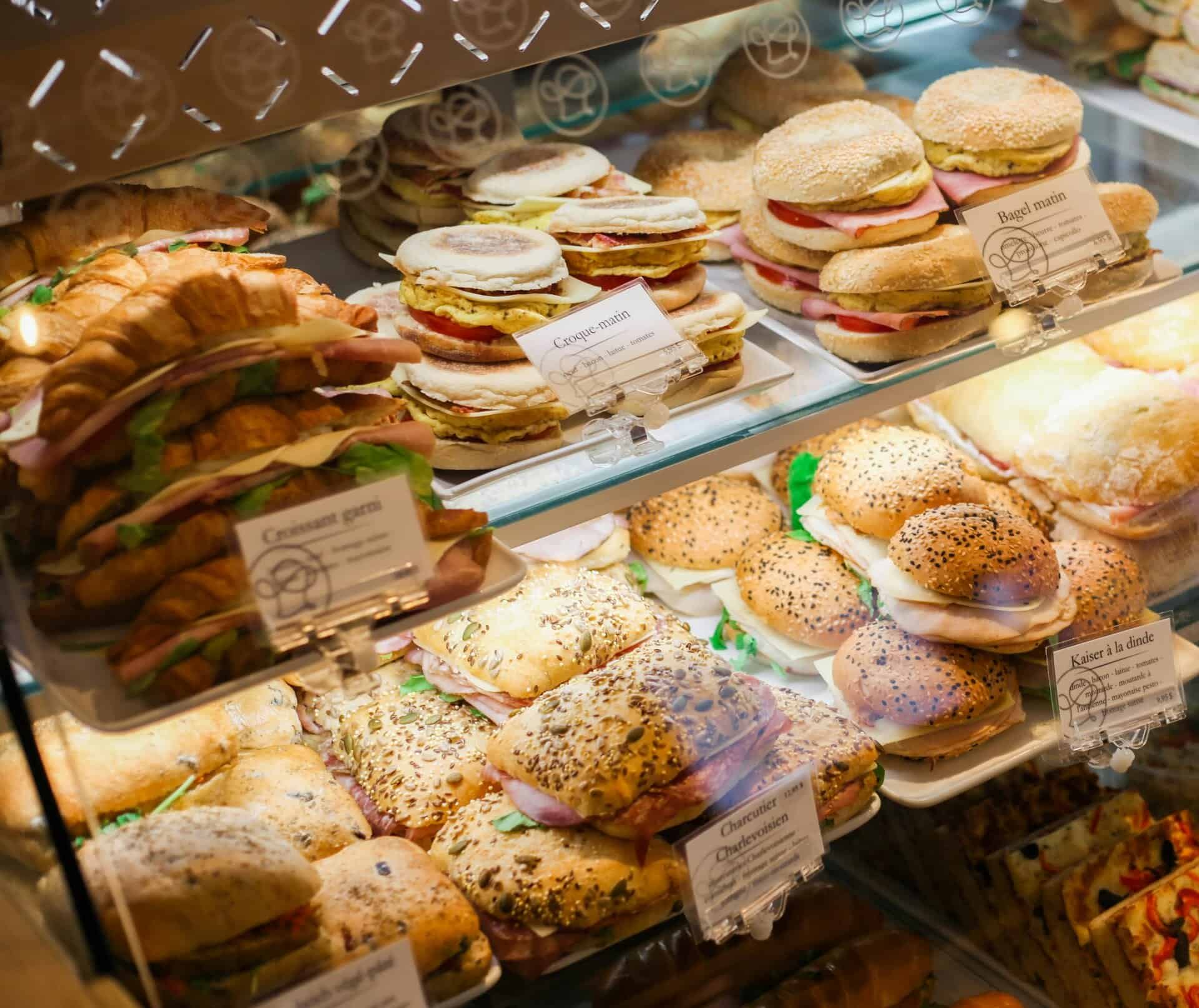 A vibrant showcase of assorted sandwiches and bagels in a Quebec bakery, captured in detail.