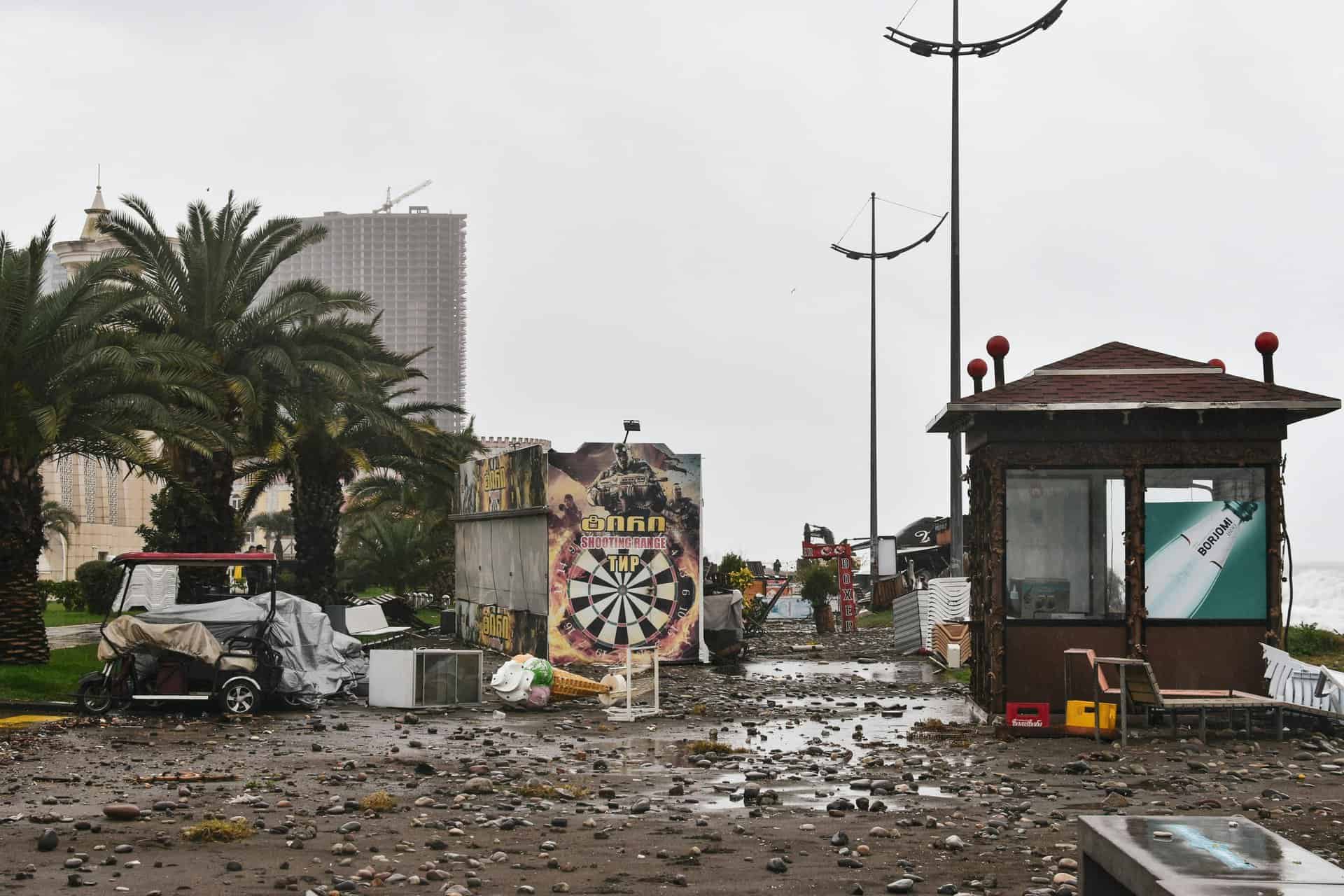 City street filled with storm debris and damaged structures under a cloudy sky., Jamaica
