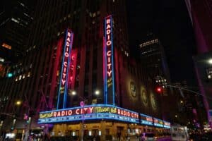 Vibrant neon lights of Radio City Music Hall illuminate New York City at night.