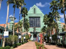 Iconic Swan Hotel at Walt Disney World in Kissimmee, FL with lush palm trees and clear skies.