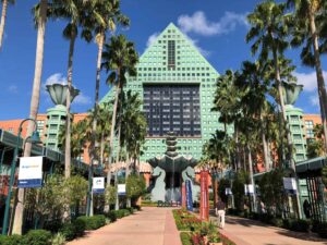 Iconic Swan Hotel at Walt Disney World in Kissimmee, FL with lush palm trees and clear skies.