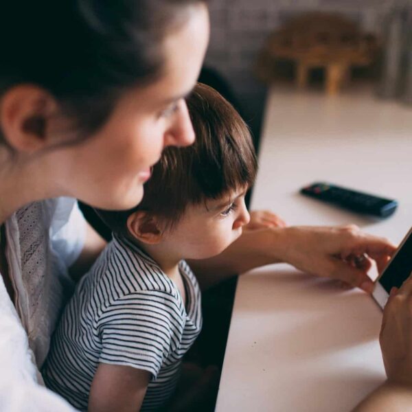 A mother and child bonding while using a smartphone at home. Parenting support from the bobo app.