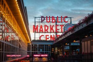 Vibrant Pike Place Market sign in Seattle, captured at dusk with neon lights glowing. Autumn.