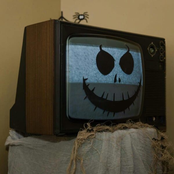 Retro TV adorned with a spooky Halloween face, creating a nostalgic eerie vibe.