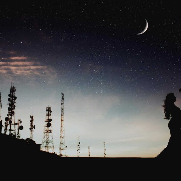 A couple's silhouette against a starry sky with a crescent moon and communication towers, creating a romantic ambiance. love languages, moon sign, astrology,