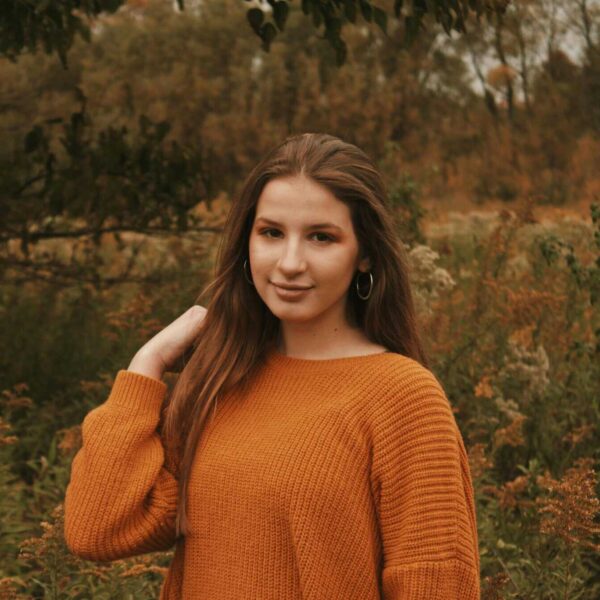 This is a photograph of a woman outside during fall. There are fun new beauty products to try out this season.