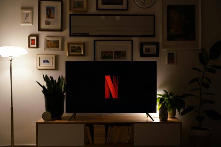 Modern living room with TV featuring a prominent logo, stylish decor and ambient lighting. Netflix, Korean Shows