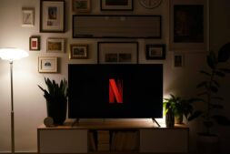 Modern living room with TV featuring a prominent logo, stylish decor and ambient lighting. Netflix, Korean Shows