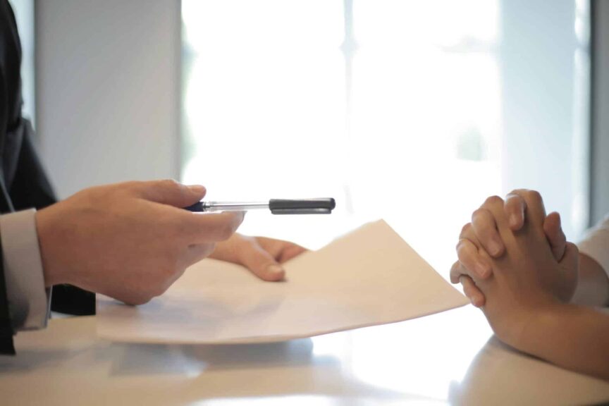Close-up of a contract signing with hands over documents. Professional business interaction. lawyer