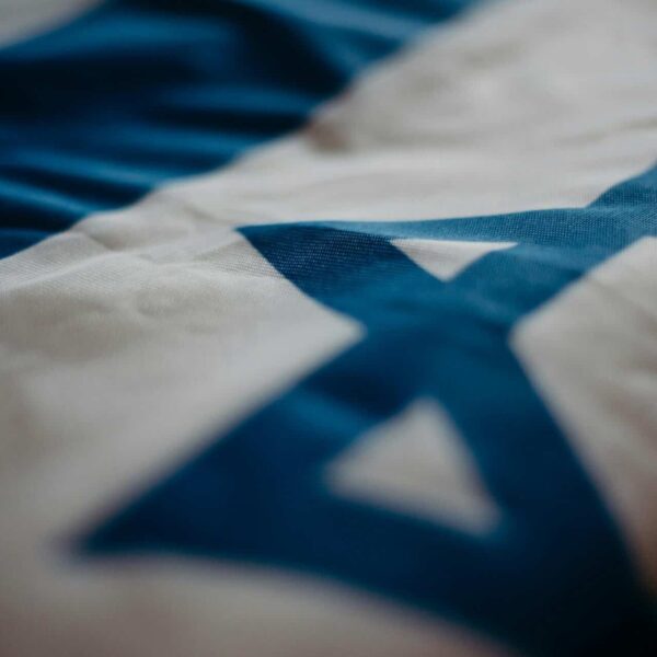 Detail of the Israeli national flag highlighting the Star of David, emphasizing its cultural significance., Warner Bros Discovery