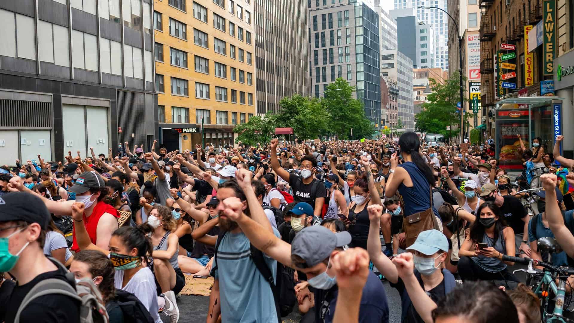 A large crowd of diverse protesters raising fists in a city street during daytime. Hollywood Stars Rally