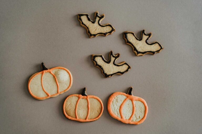 This is a photograph of cookies shaped like bats and pumpkins. Themed snacks can add to the fun of a movie night.