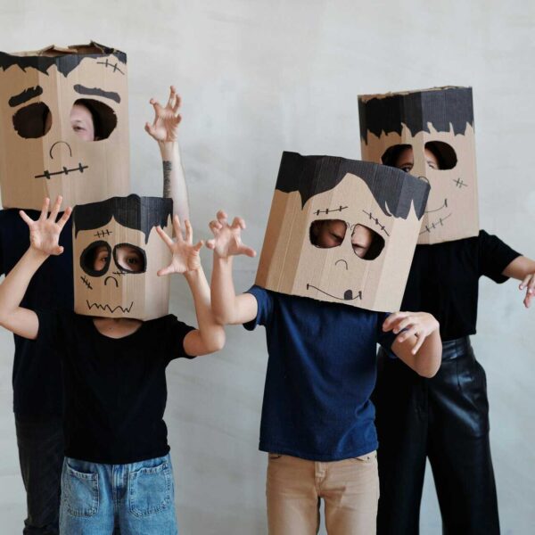 Group of children in DIY cardboard ghost costumes posing playfully for Halloween. Boo Crew, Family Halloween Costumes,