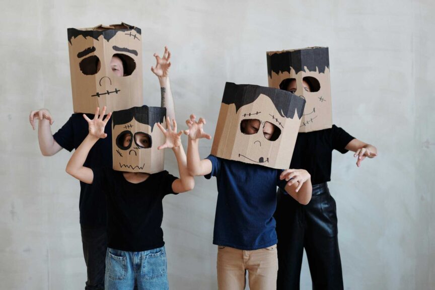 Group of children in DIY cardboard ghost costumes posing playfully for Halloween. Boo Crew, Family Halloween Costumes,