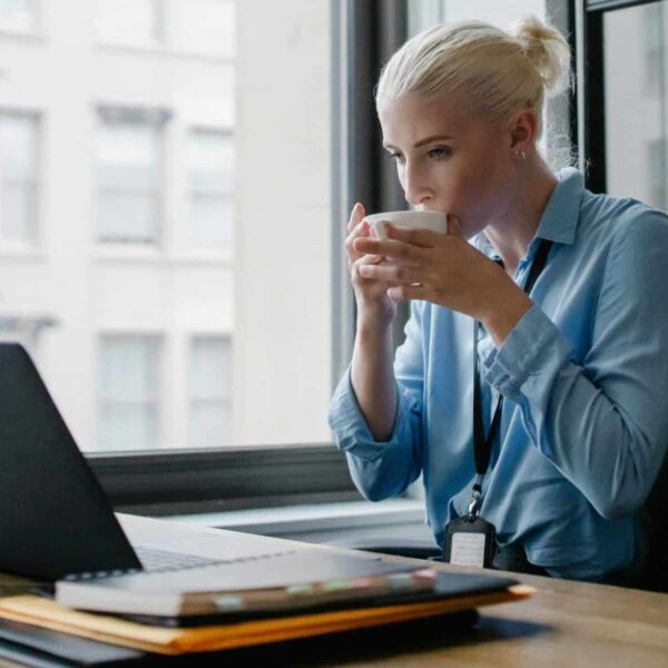 Professional woman enjoying a coffee while working at her office desk, healthier, kombucha, kefir