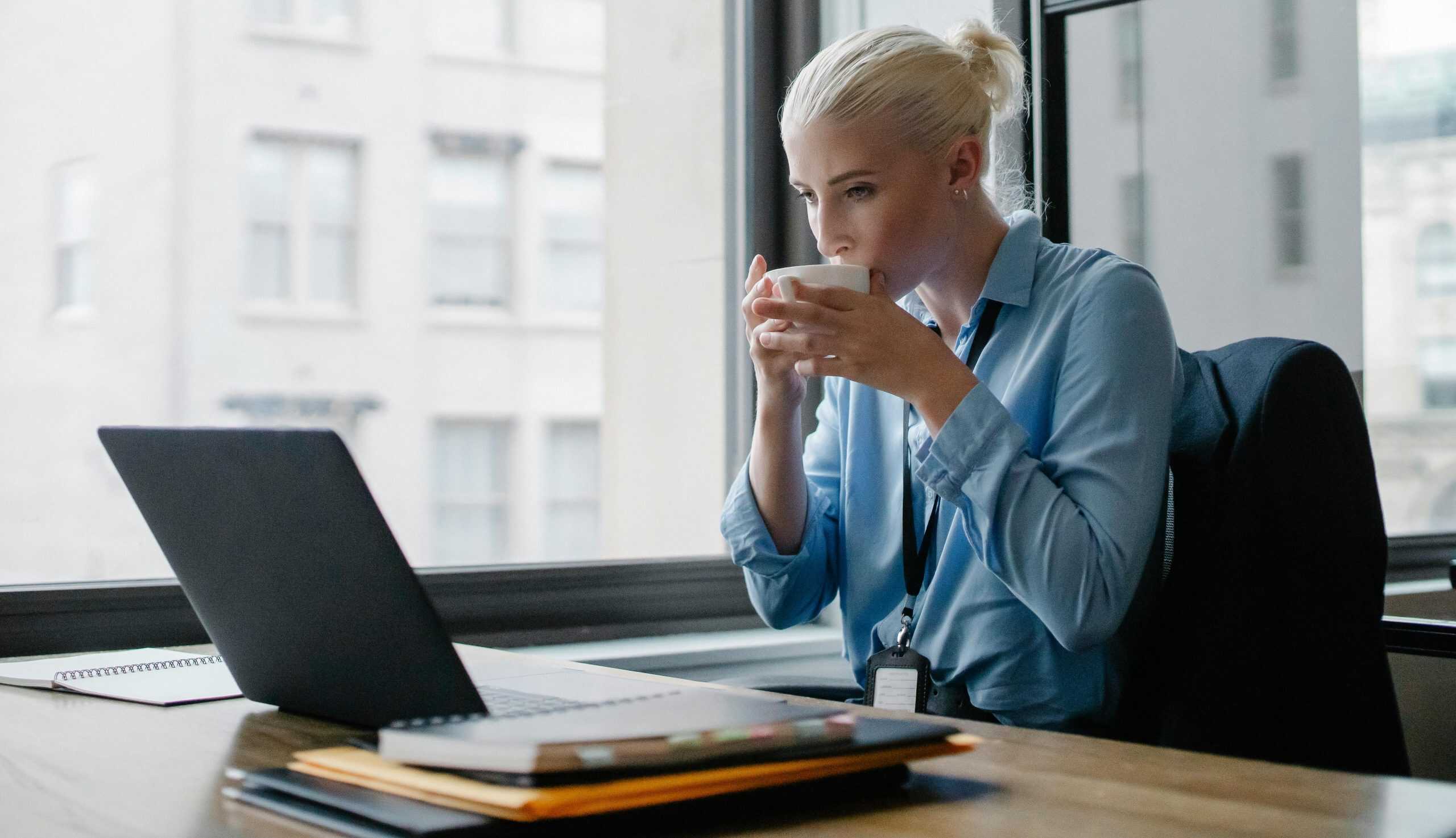 Professional woman enjoying a coffee while working at her office desk, healthier, kombucha, kefir