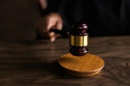 A gavel striking a sound block, symbolizing justice and legal authority in a courtroom setting. Tommy Lee, Bill Cosby