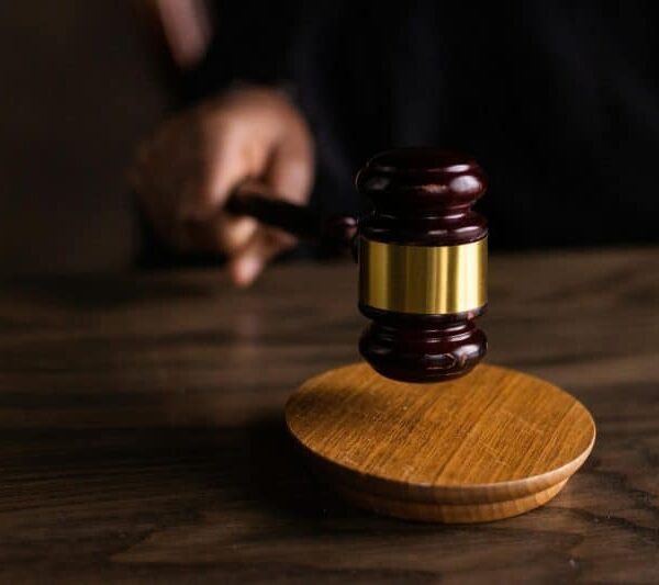 A gavel striking a sound block, symbolizing justice and legal authority in a courtroom setting. Tommy Lee, Bill Cosby