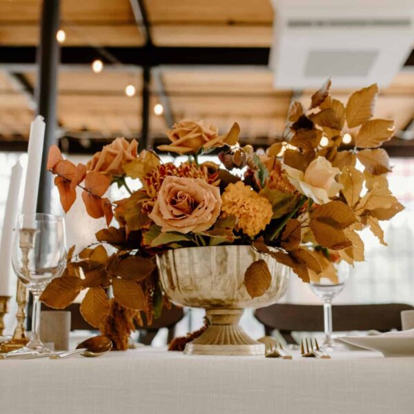 This photograph features a fall flower arrangement on an elegantly-set table. An autumn bouquet can add beauty to a room.