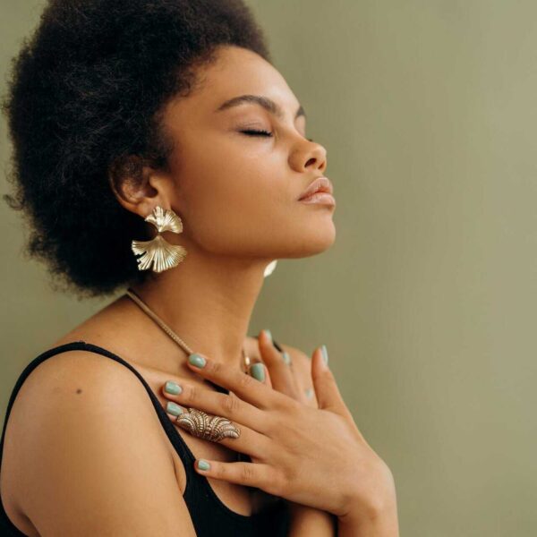 Close-up of a woman with afro hair meditating, eyes closed, embracing wellness and mindfulness, self-awareness