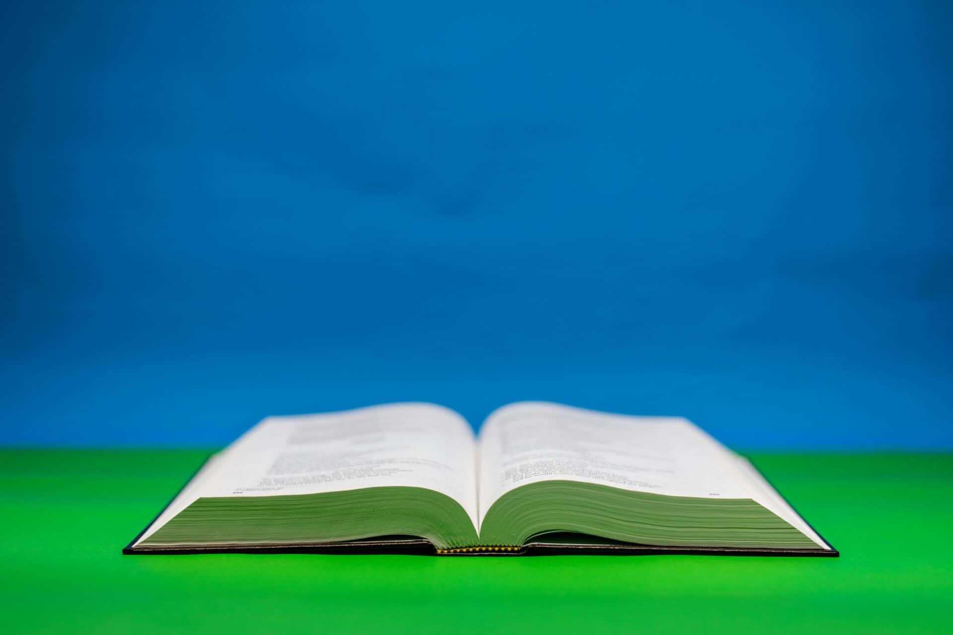 An open Bible on a vibrant green and blue backdrop symbolizing peace and spirituality, daily devotion