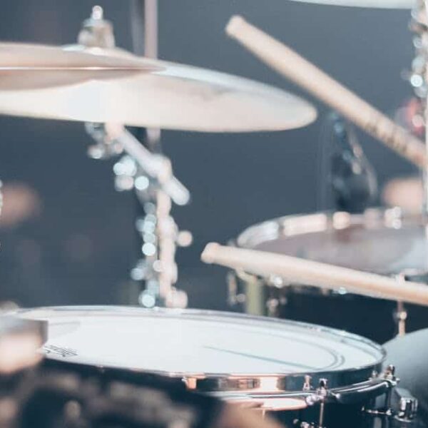 Close-up of a drummer performing on stage with focus on drum set and drumsticks. new single. Playlist