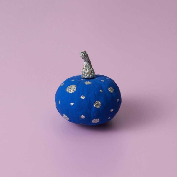 This is a photograph of a pumpkin painted blue and silver. You can apply no-carve design strategies to your pumpkins.